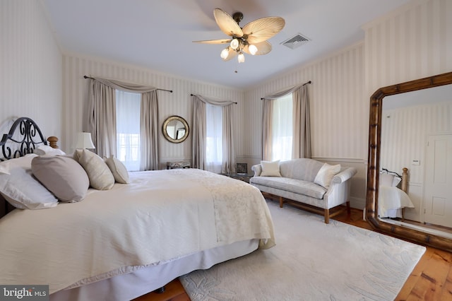 bedroom featuring multiple windows, ceiling fan, and hardwood / wood-style floors