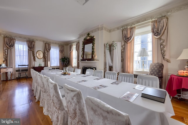 dining space with a wealth of natural light, dark hardwood / wood-style flooring, and ornamental molding