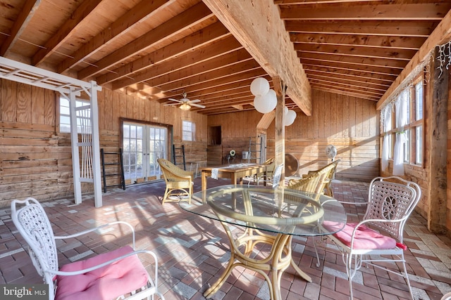 unfurnished dining area with french doors, ceiling fan, wooden walls, beam ceiling, and wooden ceiling