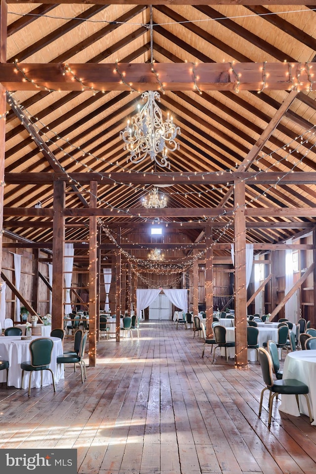 misc room with wooden ceiling, an inviting chandelier, lofted ceiling with beams, wooden walls, and wood-type flooring