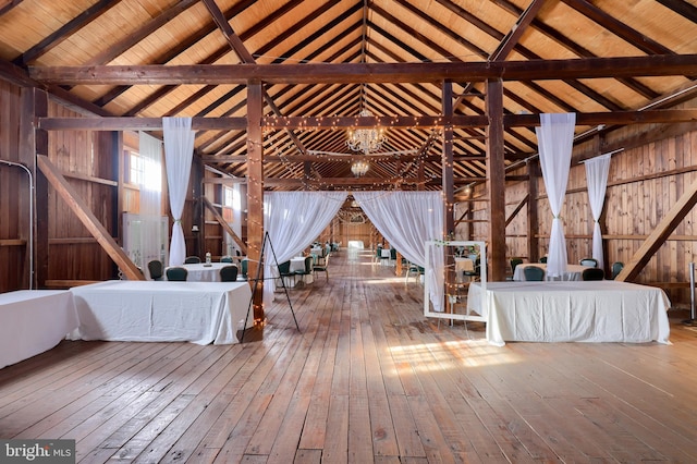 misc room with high vaulted ceiling, wooden walls, hardwood / wood-style flooring, beam ceiling, and wood ceiling