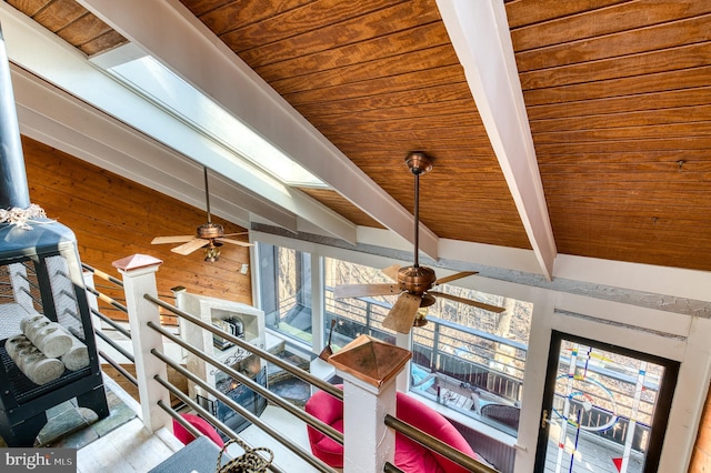 room details with beam ceiling, ceiling fan, wood walls, and wood ceiling