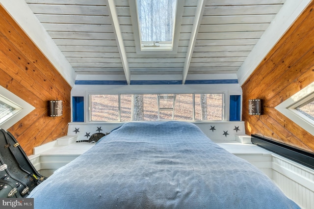 carpeted bedroom with lofted ceiling with beams, wood walls, wooden ceiling, and multiple windows