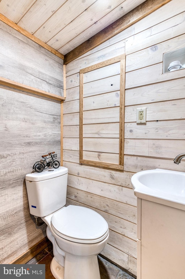 bathroom with wood walls, vanity, wooden ceiling, and toilet