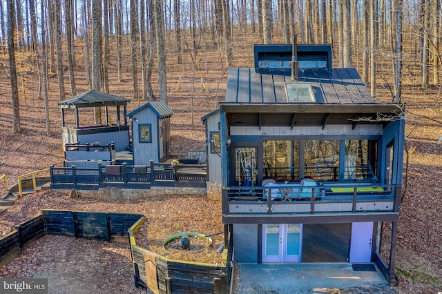 rear view of property featuring a deck and french doors