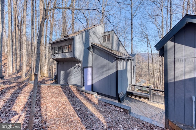 view of property exterior with a wooden deck