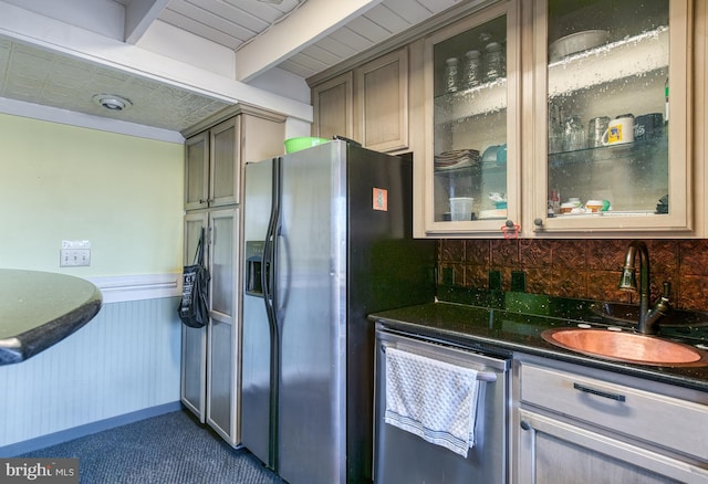 kitchen with beam ceiling, sink, stainless steel appliances, tasteful backsplash, and dark stone counters