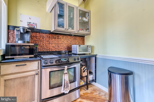 kitchen with light brown cabinets, stainless steel appliances, and light wood-type flooring