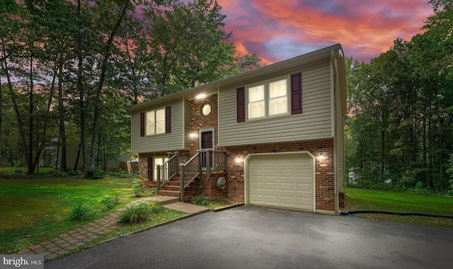 split foyer home with a garage and a yard