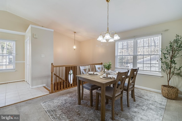 carpeted dining space featuring lofted ceiling and an inviting chandelier