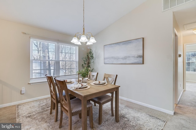 dining space with carpet floors, an inviting chandelier, and lofted ceiling