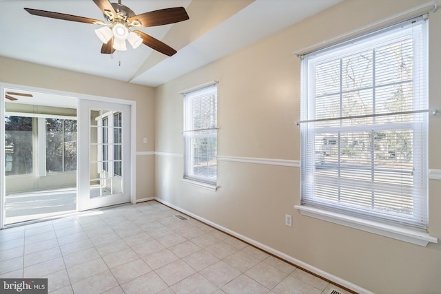 tiled spare room with a wealth of natural light, ceiling fan, and vaulted ceiling