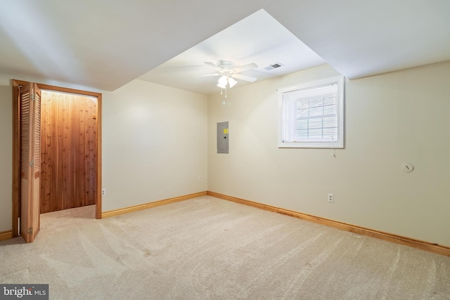 spare room featuring electric panel, light carpet, and ceiling fan