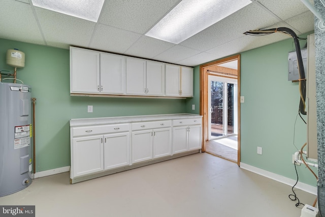 basement featuring a paneled ceiling and electric water heater