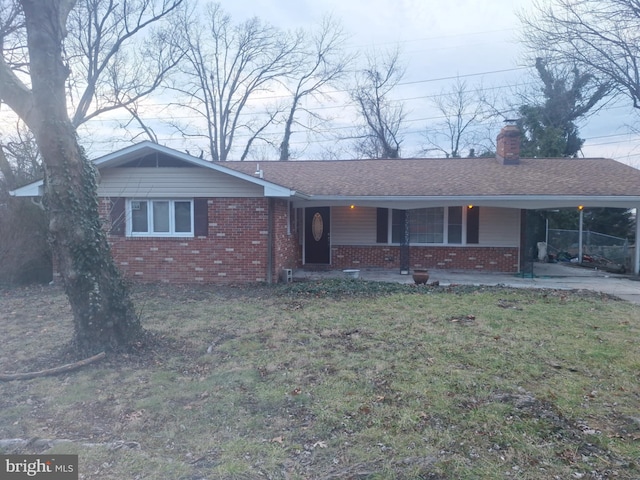 ranch-style home with a carport and a front yard