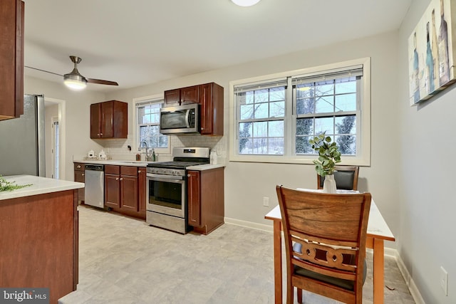 kitchen with a wealth of natural light, decorative backsplash, sink, and stainless steel appliances