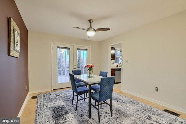 dining area featuring ceiling fan, french doors, sink, and light wood-type flooring