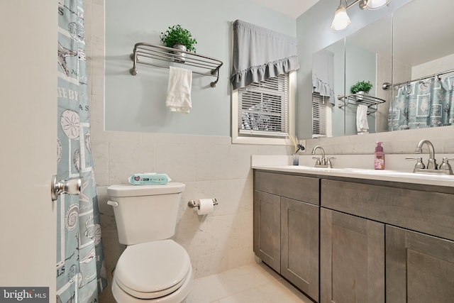 bathroom with walk in shower, tile patterned flooring, toilet, vanity, and tile walls