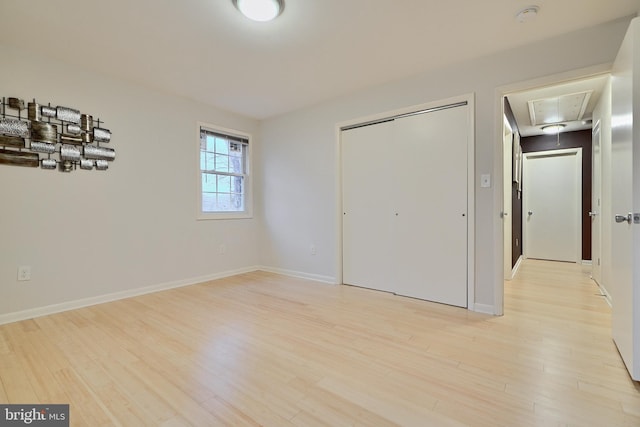 unfurnished bedroom with light hardwood / wood-style flooring and a closet