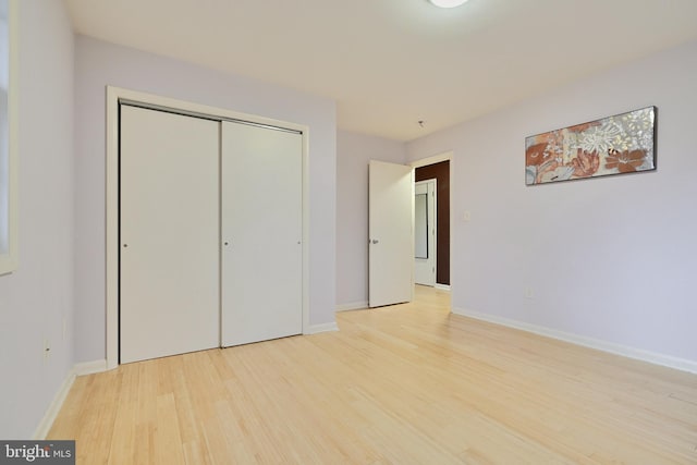 unfurnished bedroom featuring a closet and light hardwood / wood-style flooring