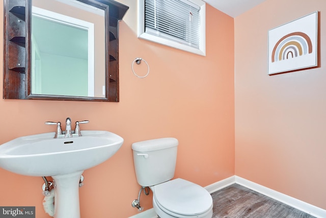 bathroom with hardwood / wood-style floors and toilet