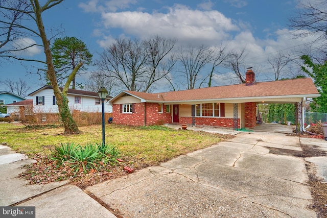 ranch-style house featuring a porch, a front yard, and a carport