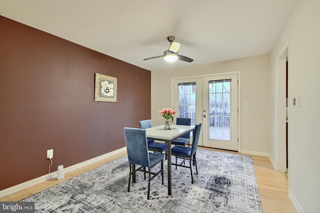 dining space with ceiling fan, light hardwood / wood-style floors, and french doors