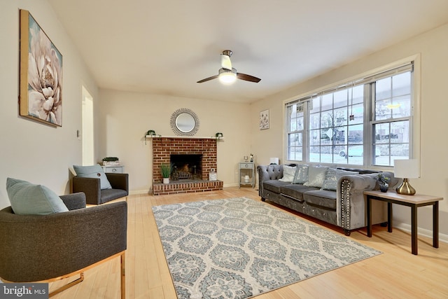 living room featuring ceiling fan, wood-type flooring, and a fireplace