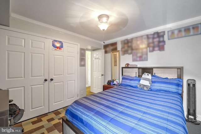 bedroom featuring a closet, ceiling fan, and ornamental molding