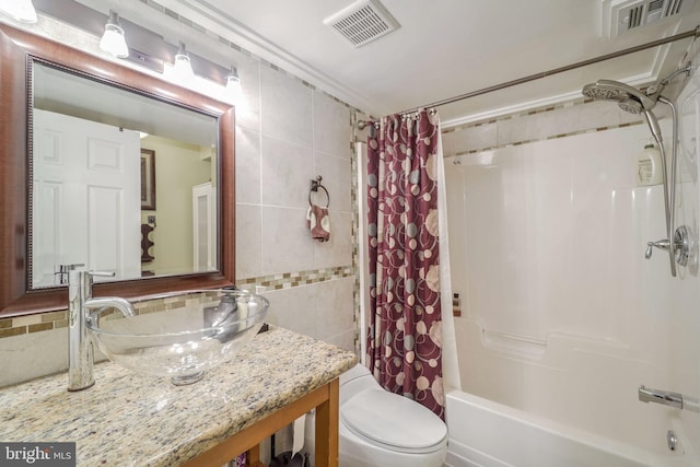 full bathroom with vanity, toilet, tile walls, and shower / bath combo with shower curtain