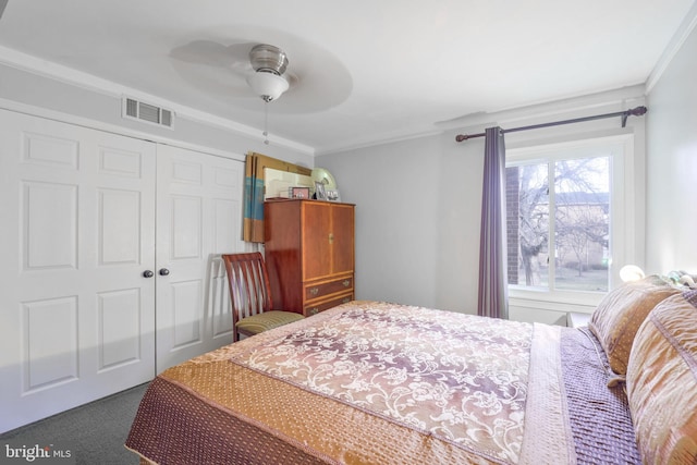 carpeted bedroom featuring ceiling fan, a closet, and ornamental molding