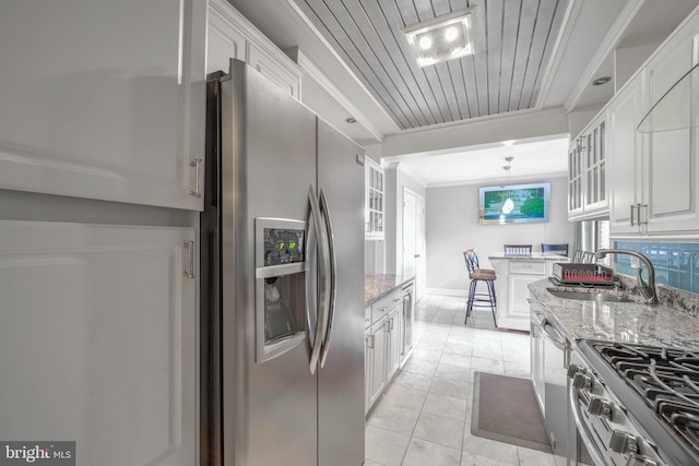 kitchen with white cabinetry, sink, light stone countertops, light tile patterned flooring, and appliances with stainless steel finishes