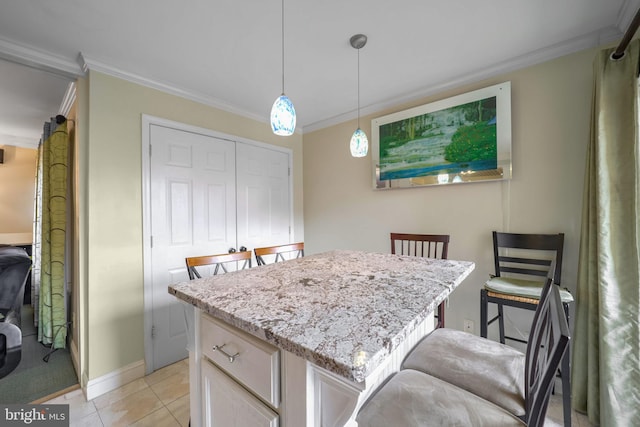 kitchen with pendant lighting, a center island, light tile patterned floors, and crown molding