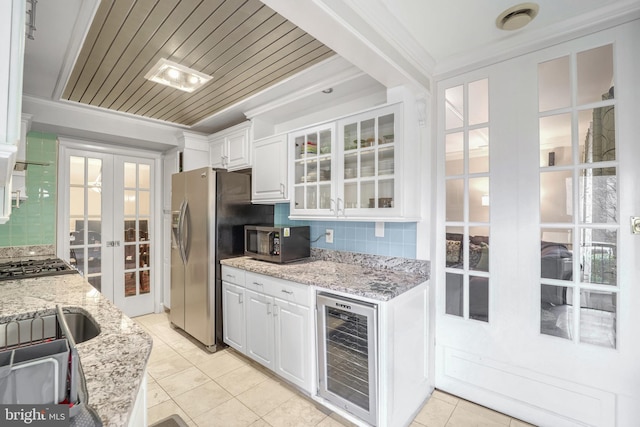 kitchen with french doors, appliances with stainless steel finishes, beverage cooler, crown molding, and white cabinets