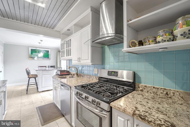 kitchen featuring white cabinets, sink, wall chimney exhaust hood, appliances with stainless steel finishes, and tasteful backsplash