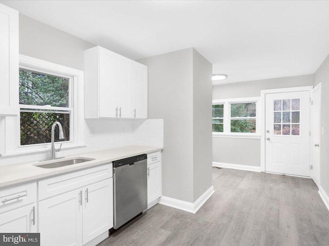 kitchen featuring tasteful backsplash, sink, light hardwood / wood-style flooring, dishwasher, and white cabinetry