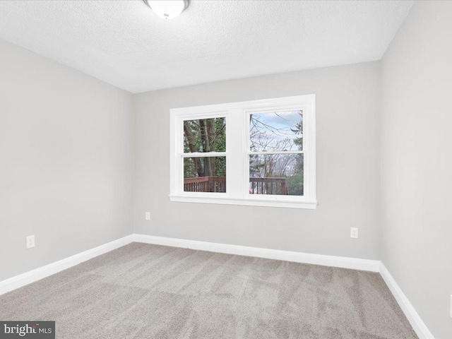 carpeted spare room with a textured ceiling