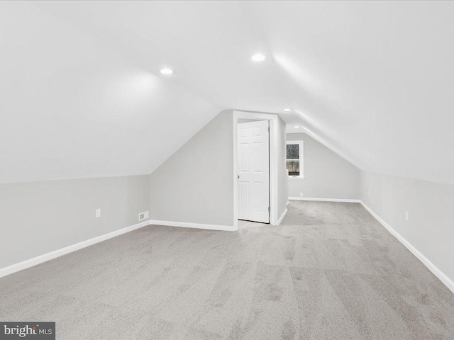 bonus room with light colored carpet and lofted ceiling