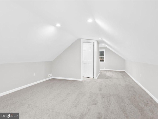 bonus room featuring lofted ceiling and light carpet