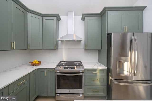 kitchen featuring green cabinets, wall chimney range hood, and appliances with stainless steel finishes