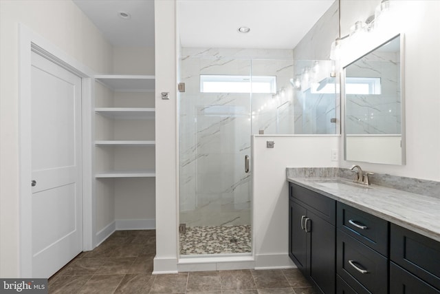 bathroom featuring plenty of natural light, a shower with shower door, and vanity