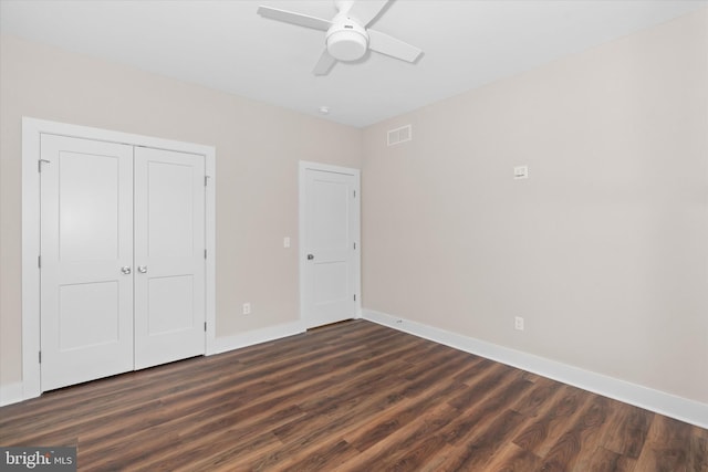 unfurnished bedroom featuring ceiling fan, dark hardwood / wood-style flooring, and a closet