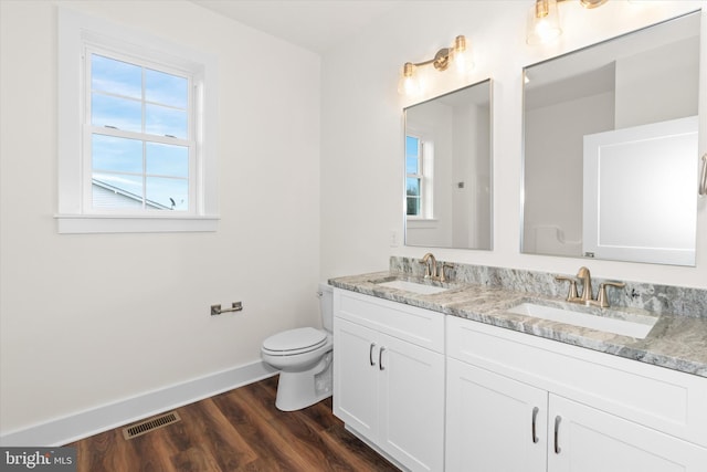 bathroom with hardwood / wood-style floors, vanity, and toilet