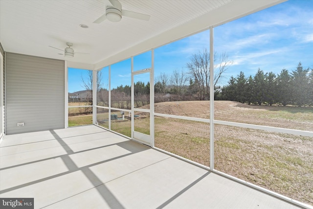 unfurnished sunroom with ceiling fan