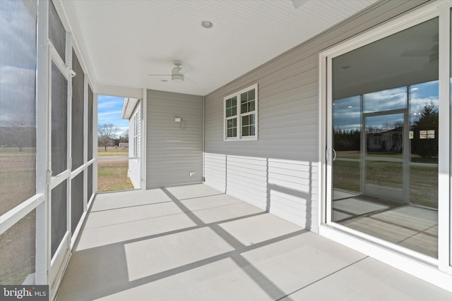 unfurnished sunroom featuring ceiling fan