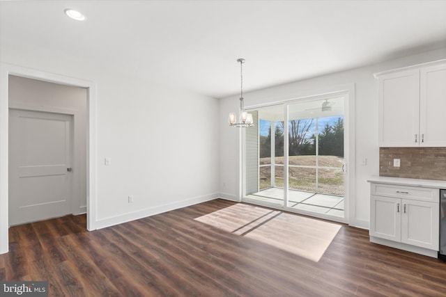 unfurnished dining area with a notable chandelier and dark wood-type flooring