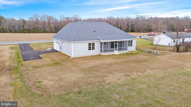 back of property featuring a sunroom and a yard