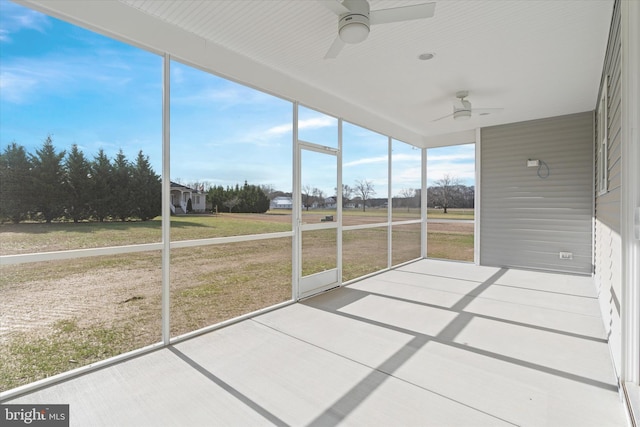 unfurnished sunroom with ceiling fan