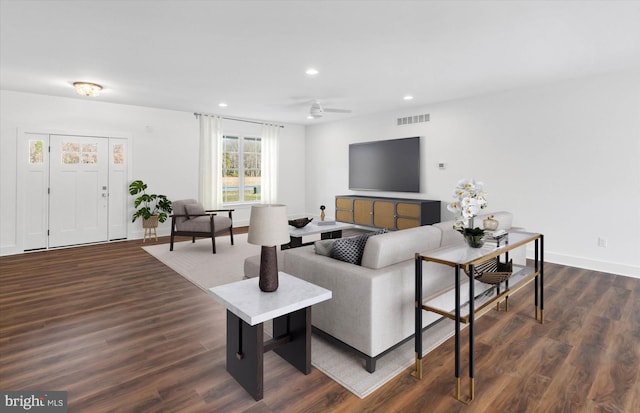 living room featuring ceiling fan and dark hardwood / wood-style floors