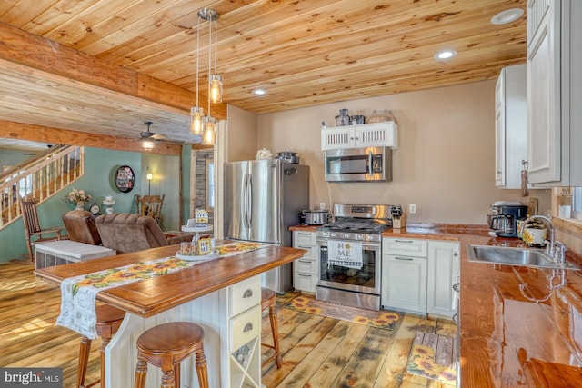 kitchen featuring wooden counters, white cabinets, sink, light hardwood / wood-style flooring, and stainless steel appliances